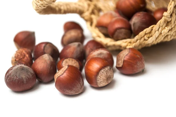 Close-up van noten die van mand op witte achtergrond vallen — Stockfoto