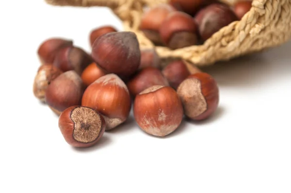 Close-up van noten die van mand op witte achtergrond vallen — Stockfoto
