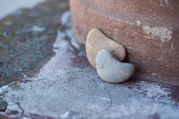 Gros plan de deux cailloux de pierre en forme de coeur sur un mur lapidé — Photo