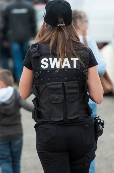 Vrouw met SWAT politie uniform lopen op de rug te bekijken — Stockfoto