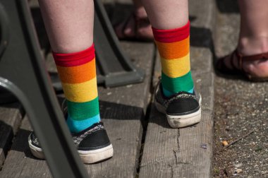 rainbow socks on lesbian girl standing in the street clipart