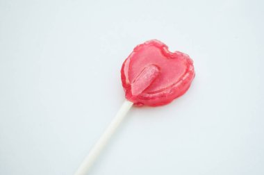 Beyaz arka plan üzerinde şekilli kalp closeup og pembe lolipop