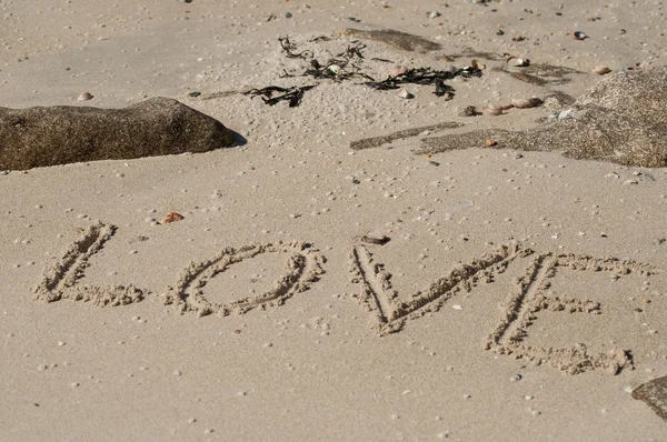 Close up of love word writting in the sand on the beach — стоковое фото