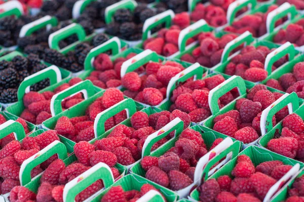 Closeup of raspberries in cardboard box at the market — Stock Photo, Image