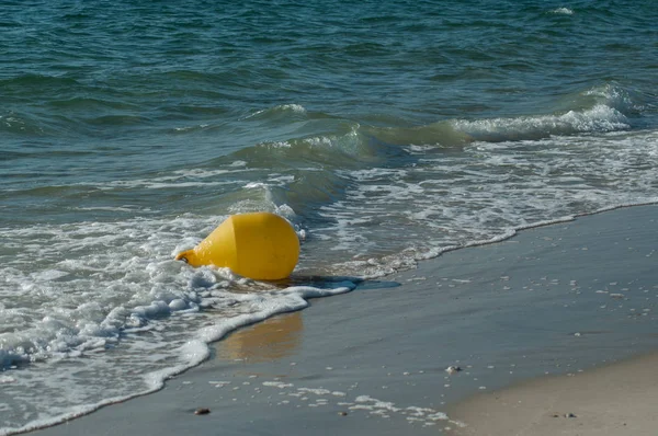 Gros plan de bouée jaune dans l'eau sur la plage — Photo
