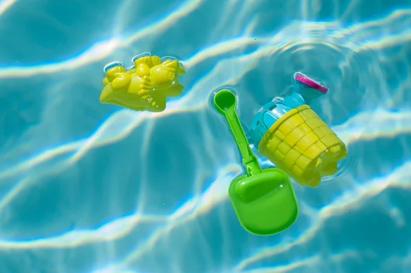 Primer plano de juguetes de plástico flotando en la piscina —  Fotos de Stock