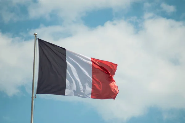 Французький прапор, що плаває на похмурих тлі неба — стокове фото