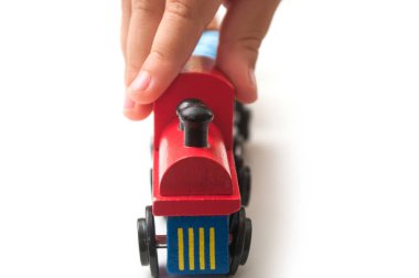 beyaz arka plan üzerinde ahşap tren ile oynayan çocuk eli