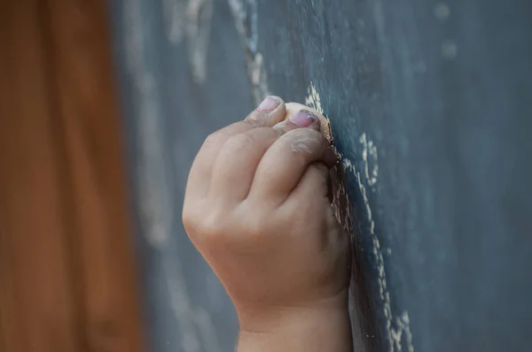 Closeup of hand of child drawing with chalk on the chalkboard — Stock Photo, Image