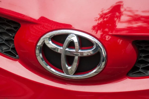 Fechar o logotipo na frente do carro Toyota vermelho estacionado na rua — Fotografia de Stock