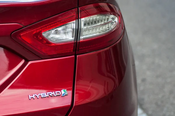 Primo piano della luce posteriore e segno sul rosso Ford Mondeo ibrido parcheggiato in strada — Foto Stock
