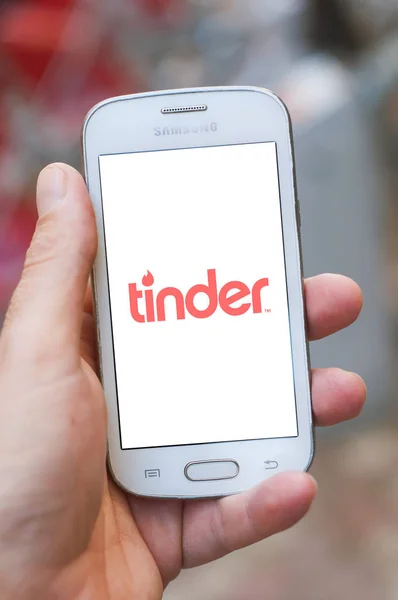 Close-up van Tinder logo op smartphone scherm in de hand van Samsung merk in de straat — Stockfoto