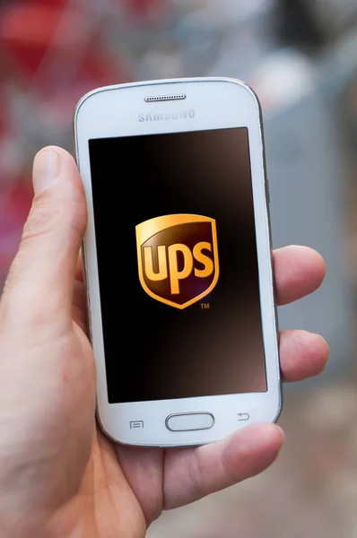 Close-up van UPS logo op smartphone scherm in de hand van Samsung merk in de straat — Stockfoto