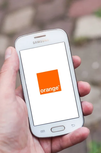 Fechar o logotipo laranja na tela do smartphone na mão da marca Samsung na rua — Fotografia de Stock