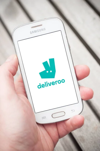 Deliveroo logó az okostelefon képernyőjén a kezében a Samsung márka az utcán — Stock Fotó