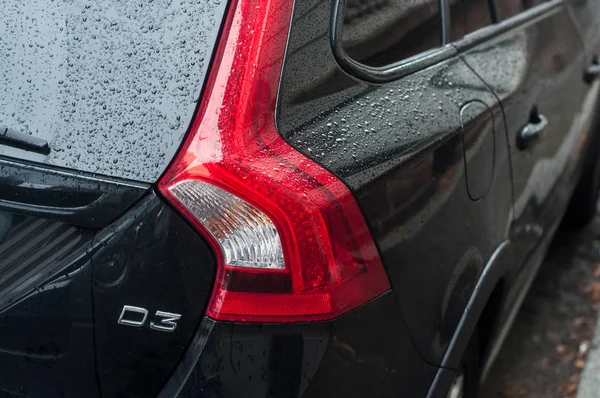 Framifrån mot regndroppar på svart ny Volvo på bakifrån parkerad på gatan — Stockfoto