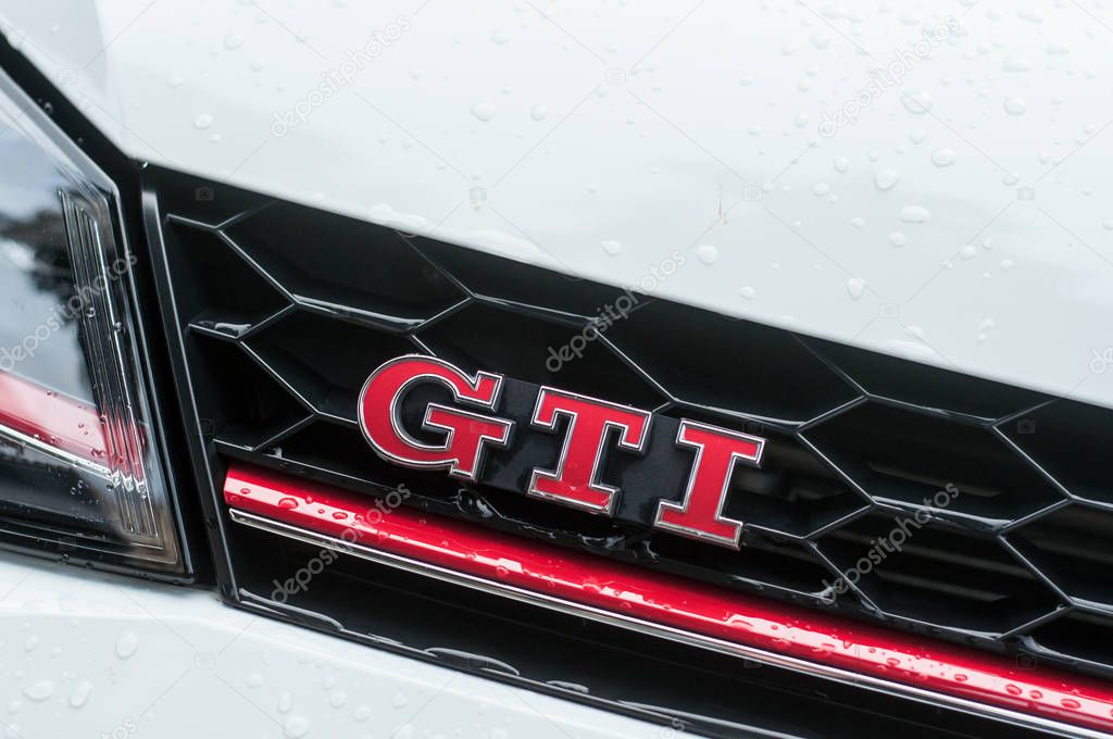 Mulhouse - France - 8 September 2019 - Closeup of rain drops of GTI sign on white Volkswagen Golf GTI front parked in the street
