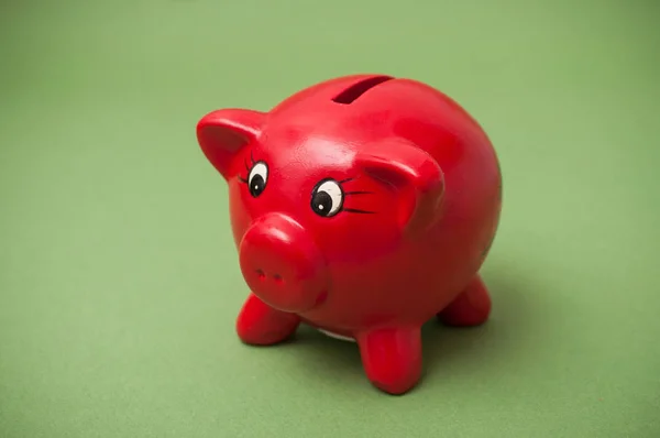 Fechar do banco piggy vermelho no fundo verde — Fotografia de Stock