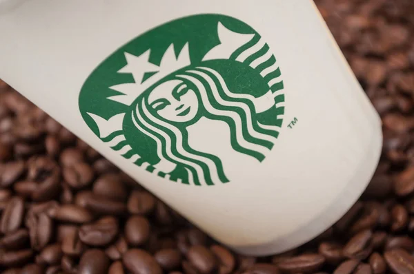 Starbucks csésze kávét kávébab háttér — Stock Fotó