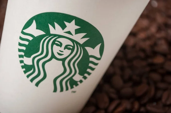 Closeup egy Starbucks csésze kávét kávébab háttér — Stock Fotó