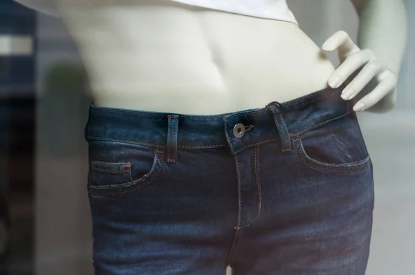 Primer plano de vaqueros azules en el maniquí en una tienda de moda para mujeres — Foto de Stock