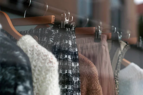 Primo piano di vestiti invernali su appendini in un negozio di moda femminile — Foto Stock
