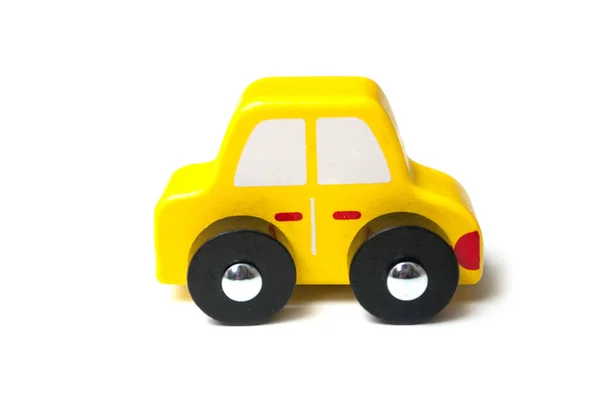 Zbliżenie żółty miniaturowy drewniany samochód na białym tle — Zdjęcie stockowe