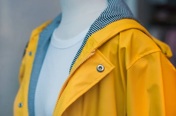 Closeup of yellow rain coat on mannequin in fashion store