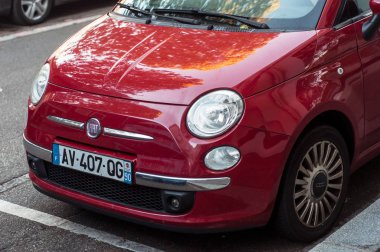  Kırmızı Fiat 500 önde, caddeye park edilmiş.