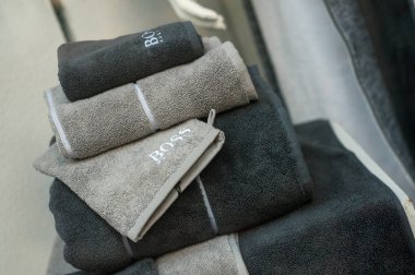 Hugo Boss 'un mağazadaki markasından mavi ve gri banyo havluları yığılıyor. 