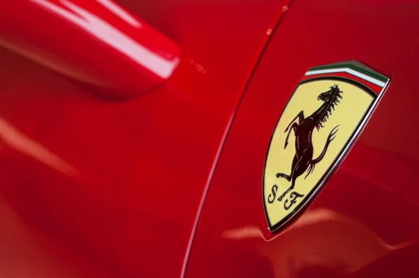 Logo Ferrari en coche deportivo rojo en ferrari sala de exposición minorista — Foto de Stock