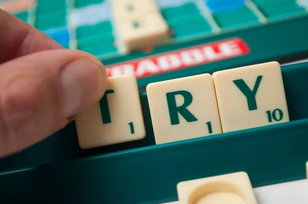 Пластиковые буквы на Scrabble настольная игра формирования слова: попробуйте — стоковое фото