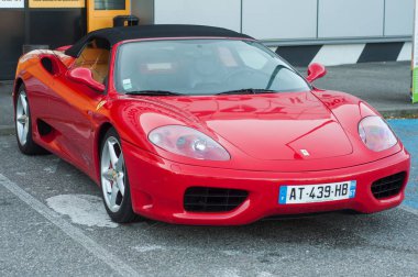 Kırmızı Ferrari 360 Modena 'nın önü sokağa park edilmiş.
