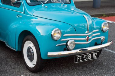 Mavi Renault 4cv 'nin önü caddeye park edilmiş. 
