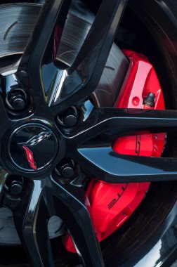 Caddeye park edilmiş Chevrolet Corvette arabasının siyah tekerleğinde kırmızı fren. 