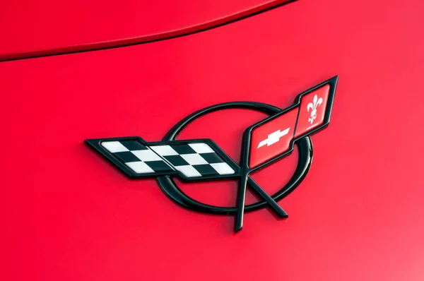 赤いシボレーコルベットのフロントのロゴが通りに駐車 — ストック写真