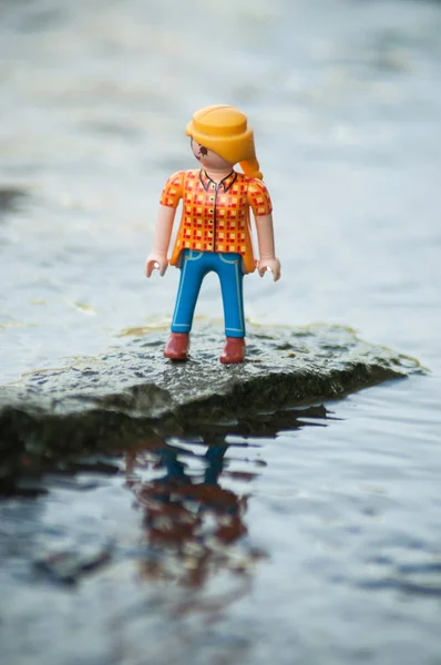 屋外で川の真ん中に岩の上にPlaymobil figure — ストック写真