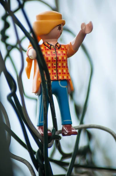 Playmobil статуэтки на металлический забор на открытом воздухе — стоковое фото
