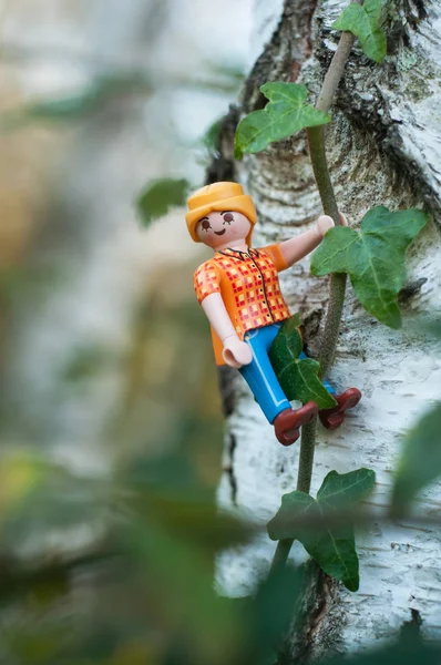 屋外で木の幹に登るPlaymobil figure — ストック写真