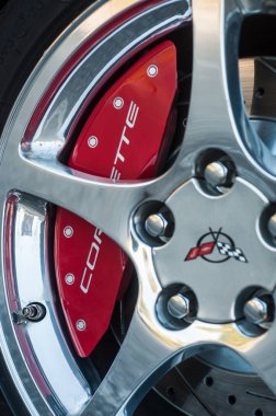 Caddeye park edilmiş Chevrolet Corvette 'in krom tekerleğinde kırmızı fren.
