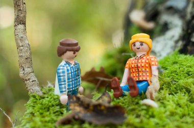 Ormandaki yosunlarda oturan oyuncak bebekler. 