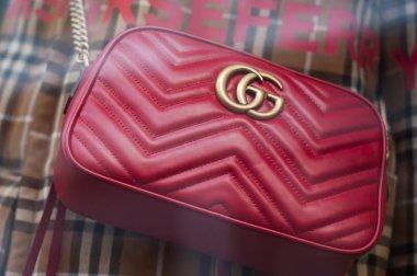Gucci marka kırmızı deri lüks bir moda mağazasında sergileniyor.