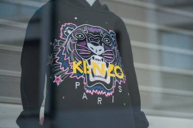 Kenzo lüks bir moda mağazasının vitrininde duruyor.