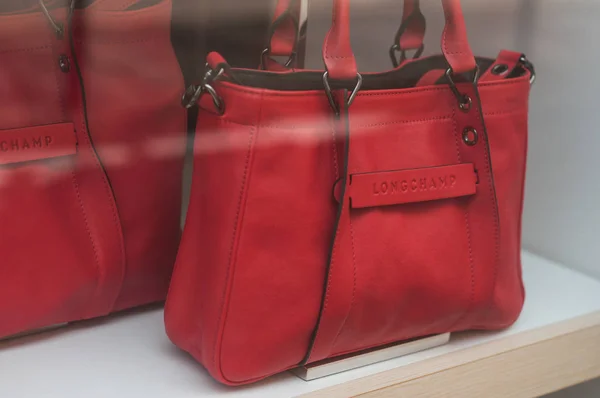 Красная кожаная сумка от бренда Longchamp в магазине моды класса люкс — стоковое фото