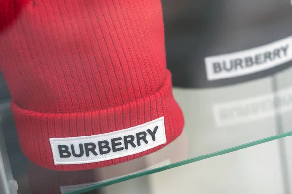 Красная и черная шерстяная шапка Burberry в салоне модного магазина — стоковое фото