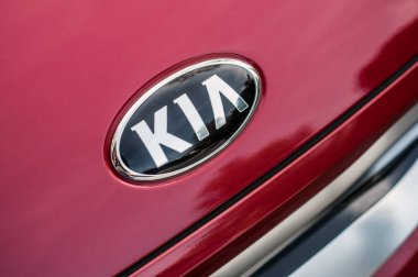 Caddeye park etmiş kırmızı SUV arabasının üzerindeki Kia logosu.