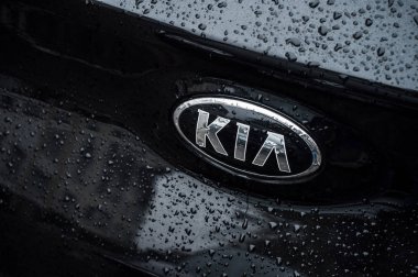 Kia logosuna yağmur damlaları. Siyah arabanın üzerine. Arka tarafa park edilmiş.