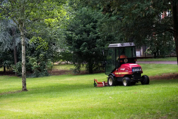 직원들이 트랙터와 잔디깎는 기계를 공원에 잔디밭을 관리하고 — 스톡 사진