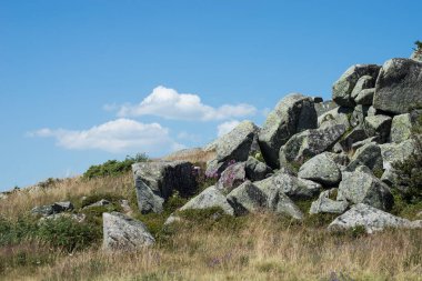 Mavi gökyüzü arkaplanındaki dağın tepesindeki megalitelerin görüntüsü