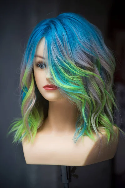 Closeup of head of mannequin with colorful hairs in a hairdresser showroom